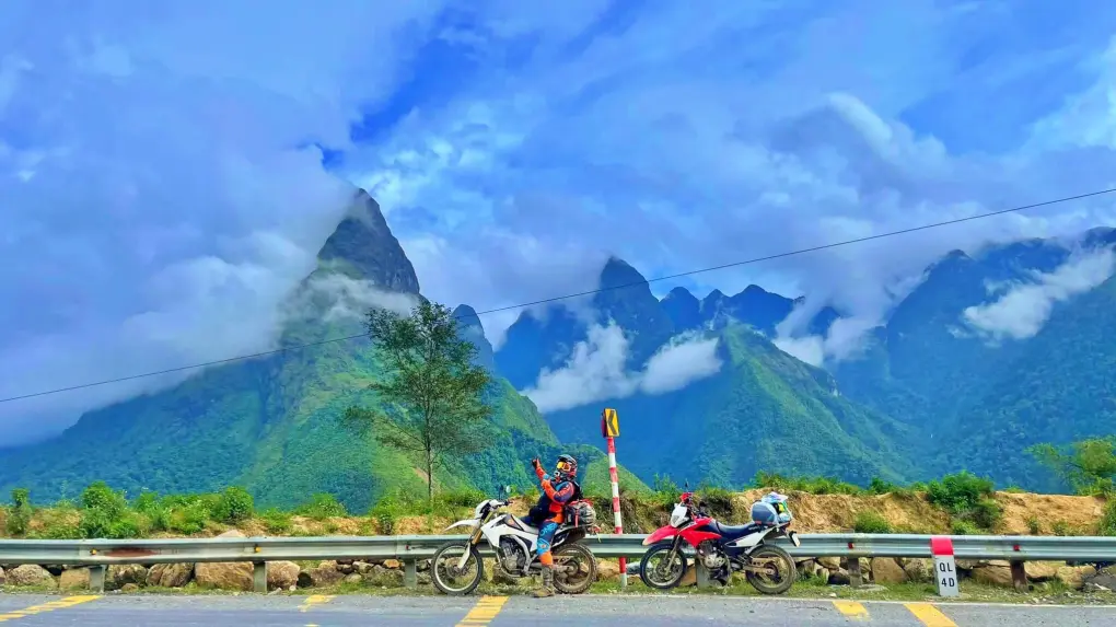 Travelers discussing Scenic Ha Giang Motorbike Routes with a local guide over a map