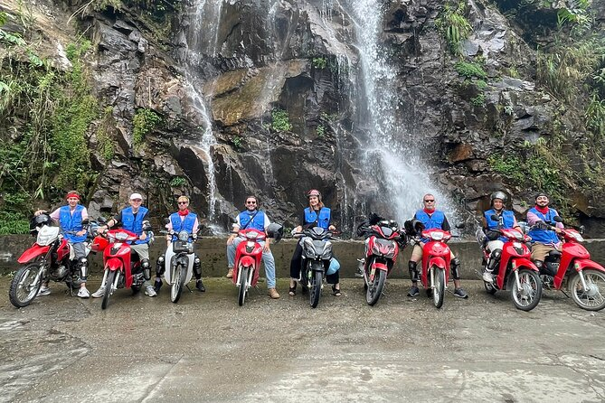 Motorbike rider crossing Scenic Ha Giang Motorbike Routes in Du Gia Valley, surrounded by rice terraces, waterfalls, and peaceful Tay ethnic villages.